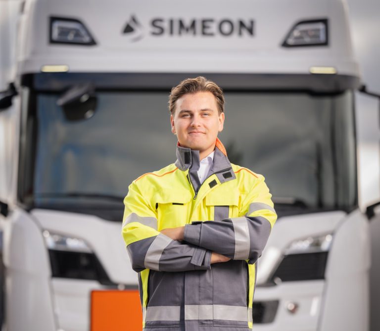 Fleet Manager standing in front of Simeon vehicle